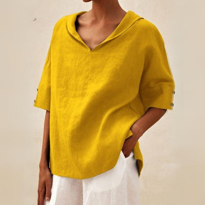 Model wearing a white relaxed V-neck top, showcasing its comfortable fit for women