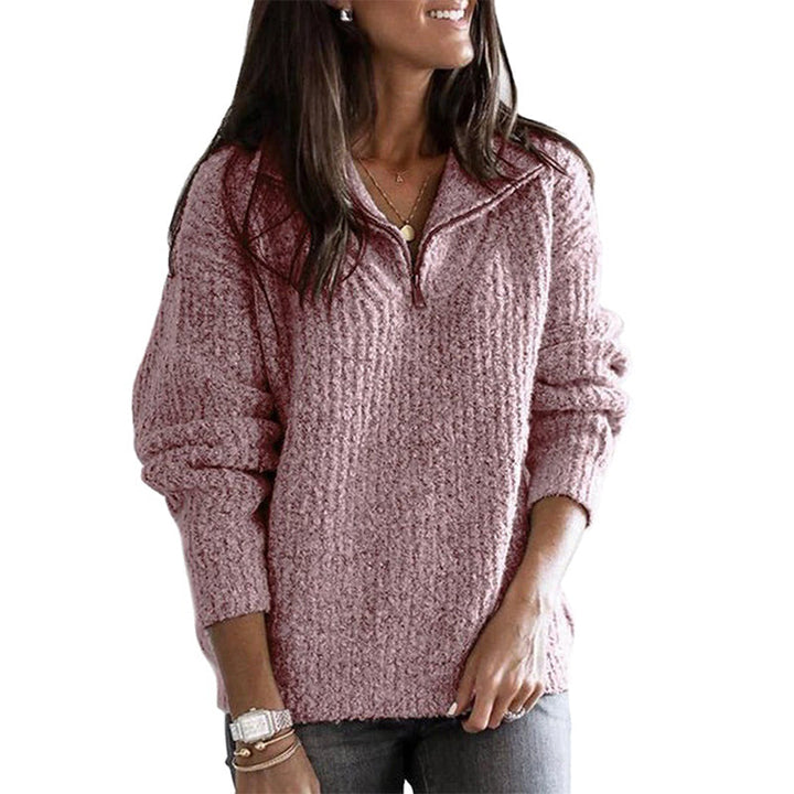Front view of a folded forest green women's ribbed zip-up sweater for comfortable everyday wear