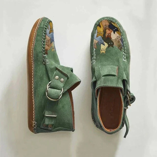 Close-up of a women's slip-on shoe, highlighting the vibrant artistic cat design and comfortable fabric.
