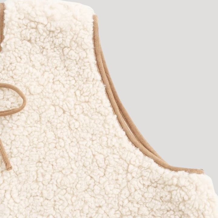 Spring fashion: beige women's vest with a tie front, offering a warm and lightweight layer.