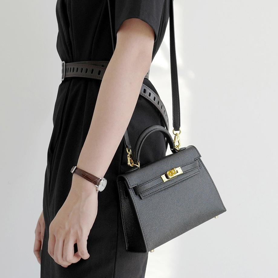 Women's structured top handle crossbody bag in black with elegant turn lock detail & shoulder strap.
