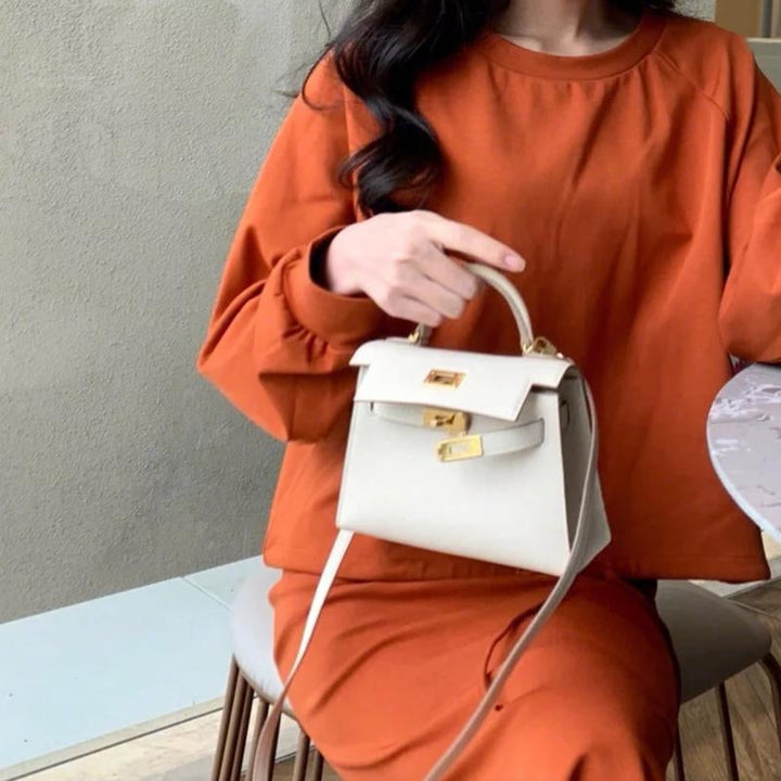 Stylish black women's top handle bag, versatile as a crossbody or shoulder purse with turn lock.