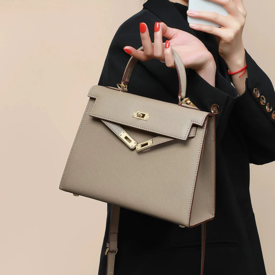 Elegant beige top handle crossbody bag for women, featuring a secure turn lock closure & structured design.