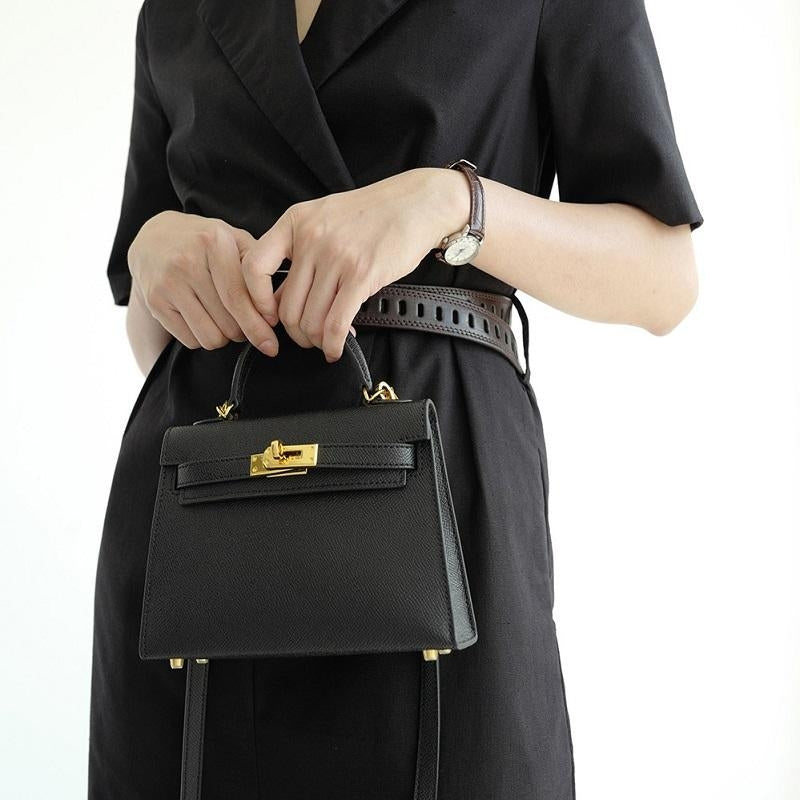 Structured black women's top handle crossbody bag, a fashion accessory with secure turn lock closure.