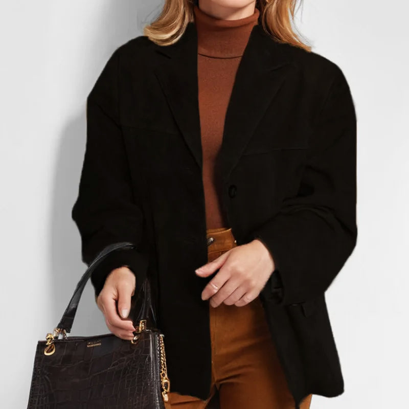Close-up of a women's tailored blazer featuring button details and fabric texture, suitable for office wear.