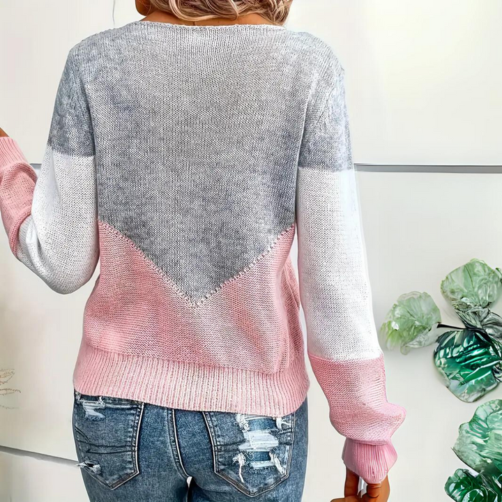 Close-up of a women's knit top, showcasing the intricate mesh detail and soft color block pattern