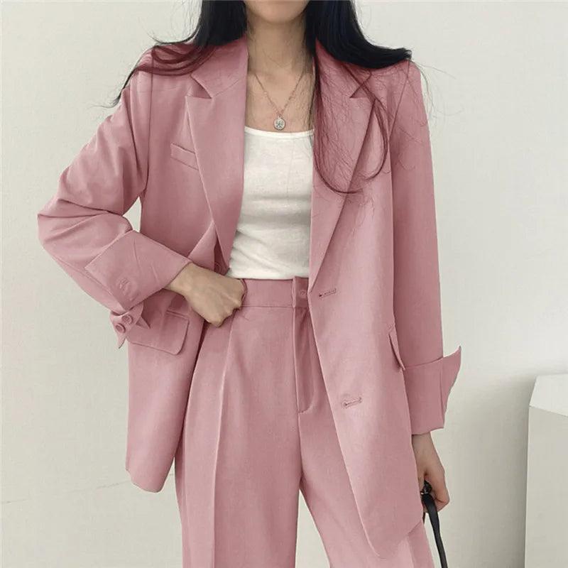 Women's tailored suit set with a long, elegant blazer and matching trousers, perfect for business attire.