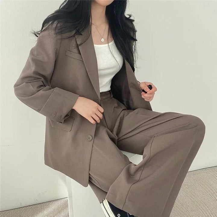 Slim-fit women's tailored suit with a long blazer and matching trousers for a streamlined silhouette.