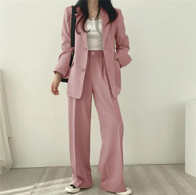 A complete women's tailored suit, showcasing a long blazer and smart trousers for professional wear.