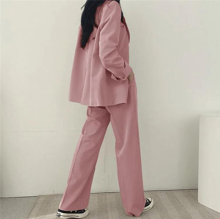 Modern women's suit set, including a long blazer and fitted trousers, perfect for office and formal events.