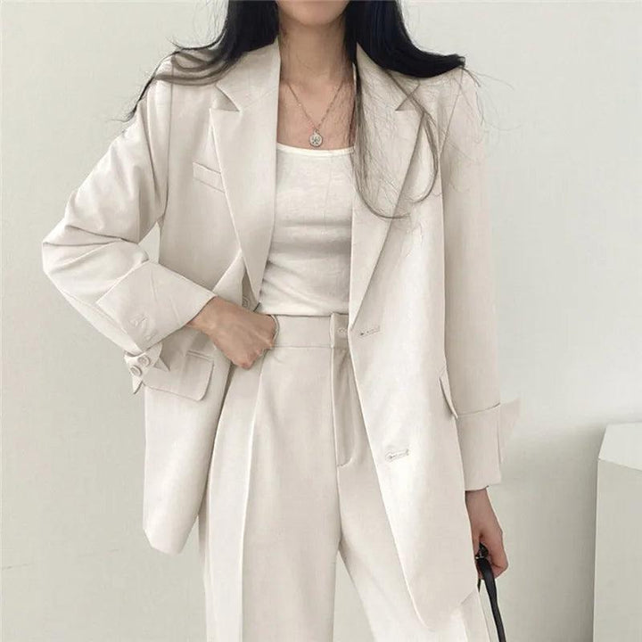 Classic women's tailored suit with an extended-length blazer and coordinated pants for business.