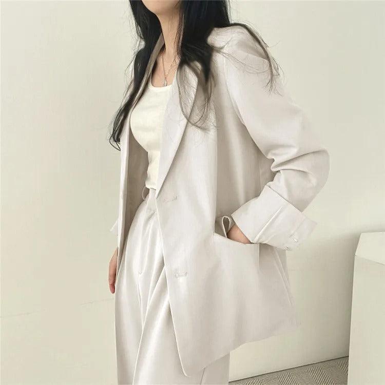 Professional women's workwear: a two-piece suit with a long blazer and sleek tailored trousers.
