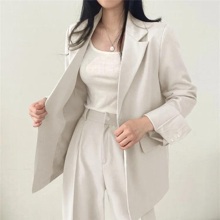Sophisticated women's business attire, featuring a longline blazer and matching tailored trousers.