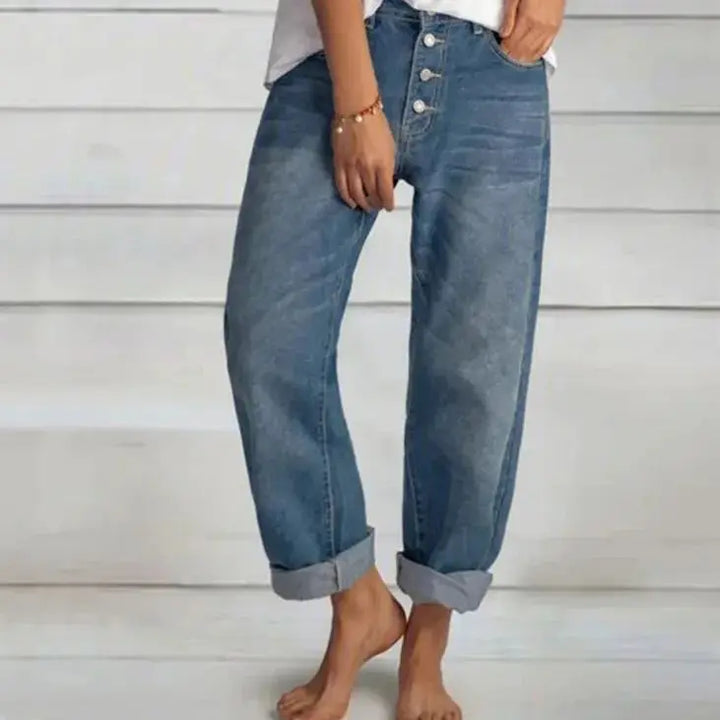 Fashionable woman wearing relaxed fit button-front blue jeans, showcasing the comfortable and casual denim style.