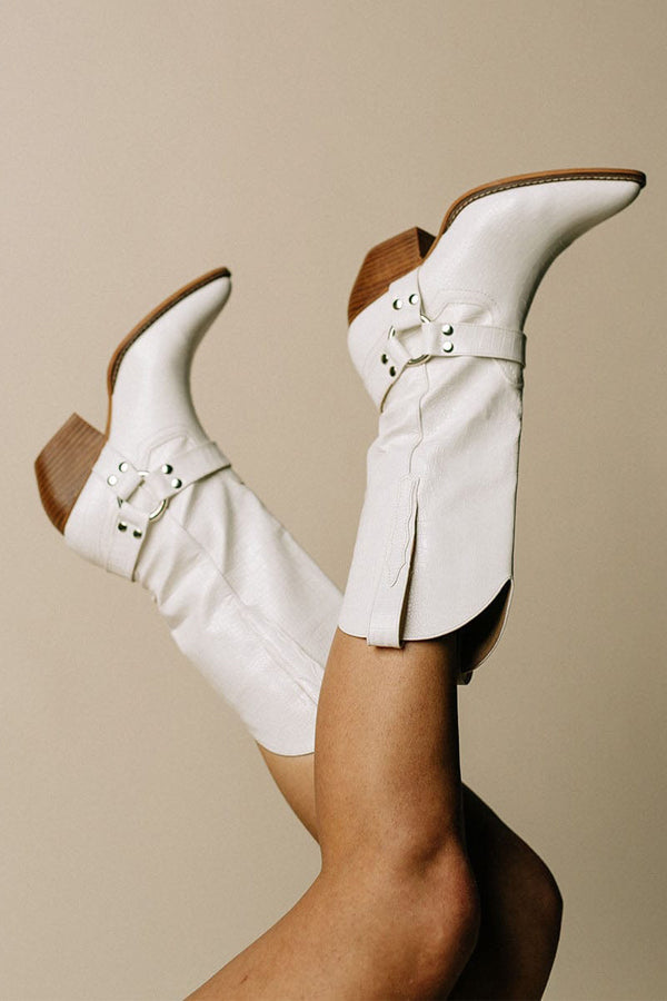 Trendy women's Western footwear: cow print boots with a stylish belt and pointed toe