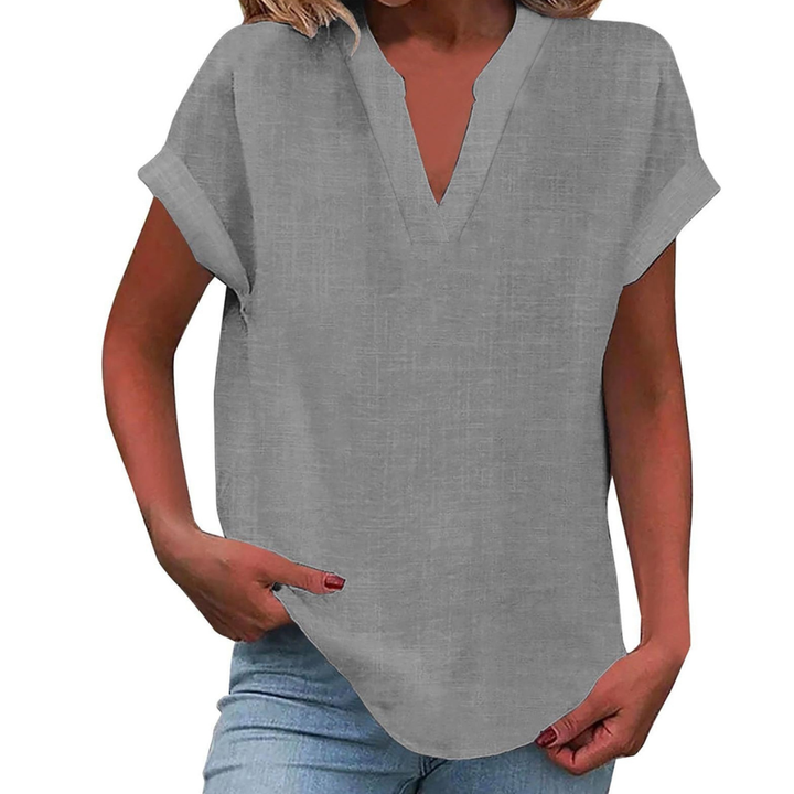 Solid color women's V-neck short sleeve blouse, showcasing its soft fabric and relaxed fit on a flat lay.