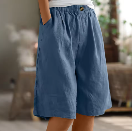 Woman wearing trendy wide leg Bermuda shorts, comfortable for summer beach or casual everyday activities.