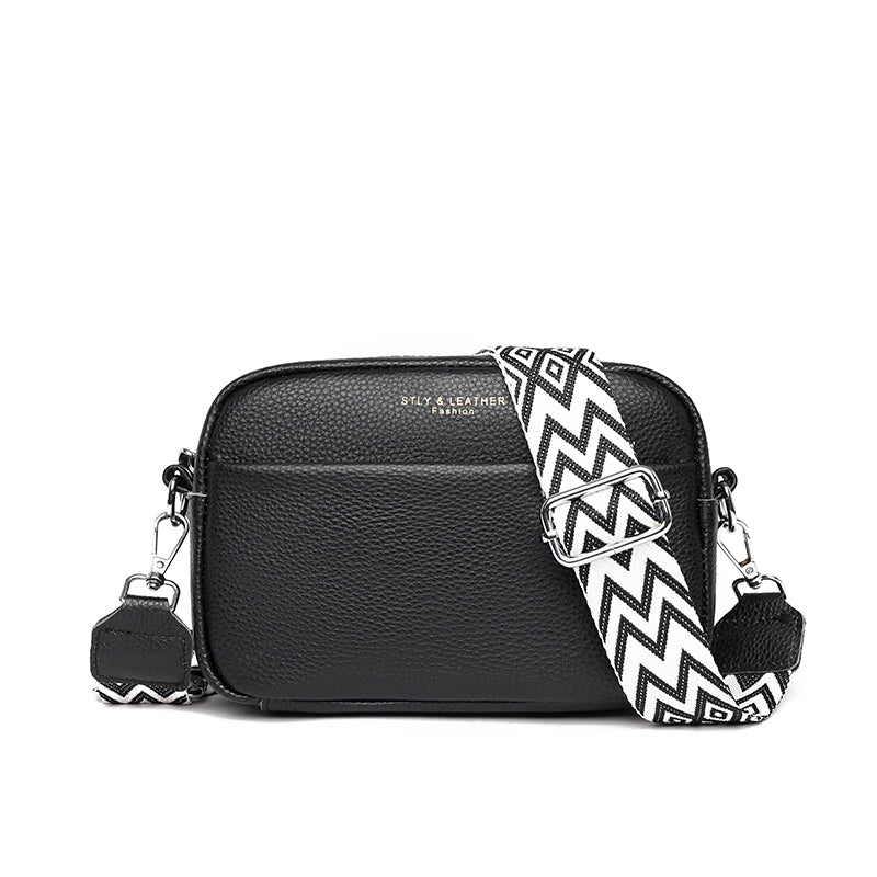 "Women's boxy camera bag with detachable chevron strap, pebbled texture, rectangular shape, and secure zip closure."