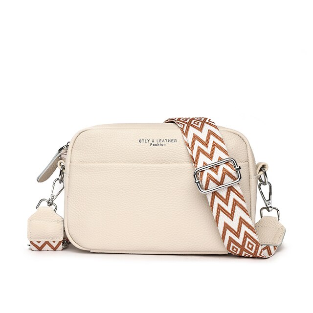 "Women's boxy camera bag with detachable chevron strap, pebbled texture, rectangular shape, and secure zip closure."