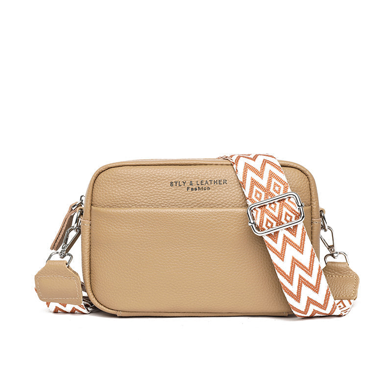 "Women's boxy camera bag with detachable chevron strap, pebbled texture, rectangular shape, and secure zip closure."