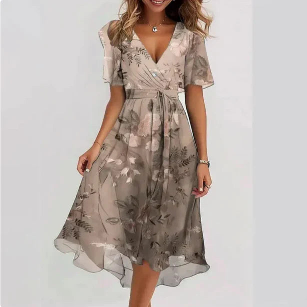 Women's floral wrap midi dress with flutter sleeves, V-neckline, asymmetrical hem, and soft floral print design.