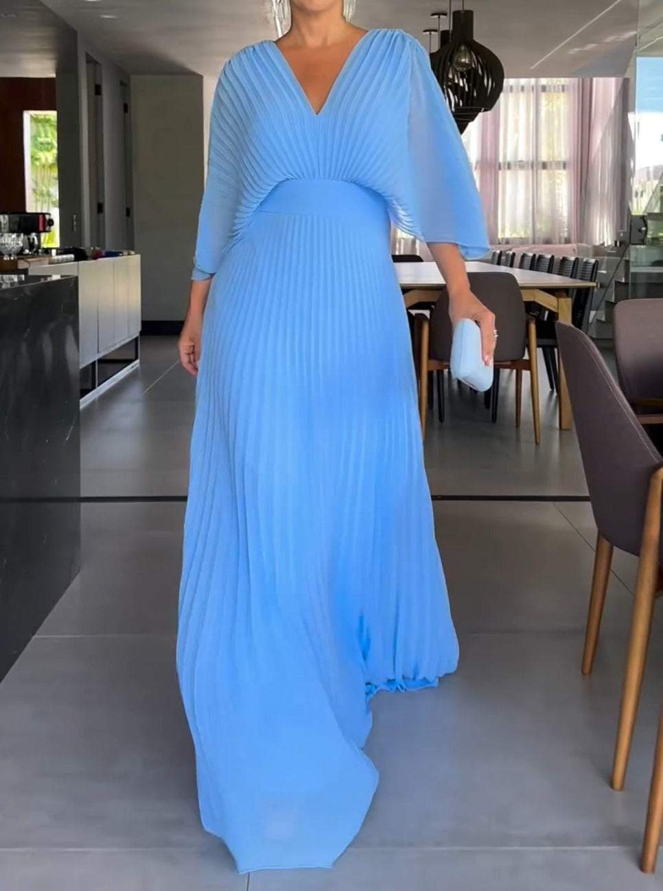 Women's pleated maxi dress with V-neck, batwing sleeves, defined waistband, elegant full-length, seen in front view.