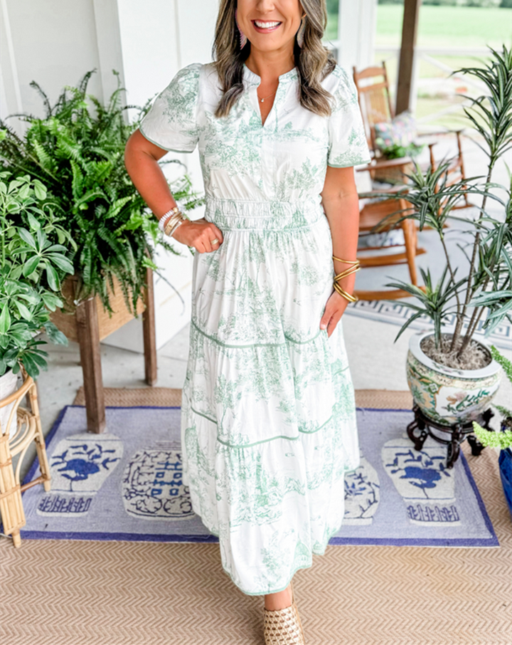 Women's toile print maxi dress with puff sleeves, showcases vintage charm with a scenic motif and fitted silhouette.