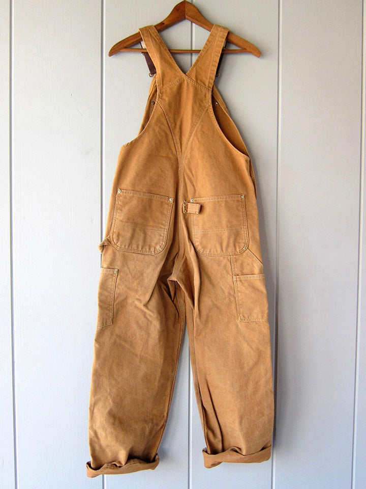 Women's utility bib overalls, adjustable straps, multi-patch pockets, wide-leg fit, durable, stylish canvas workwear.