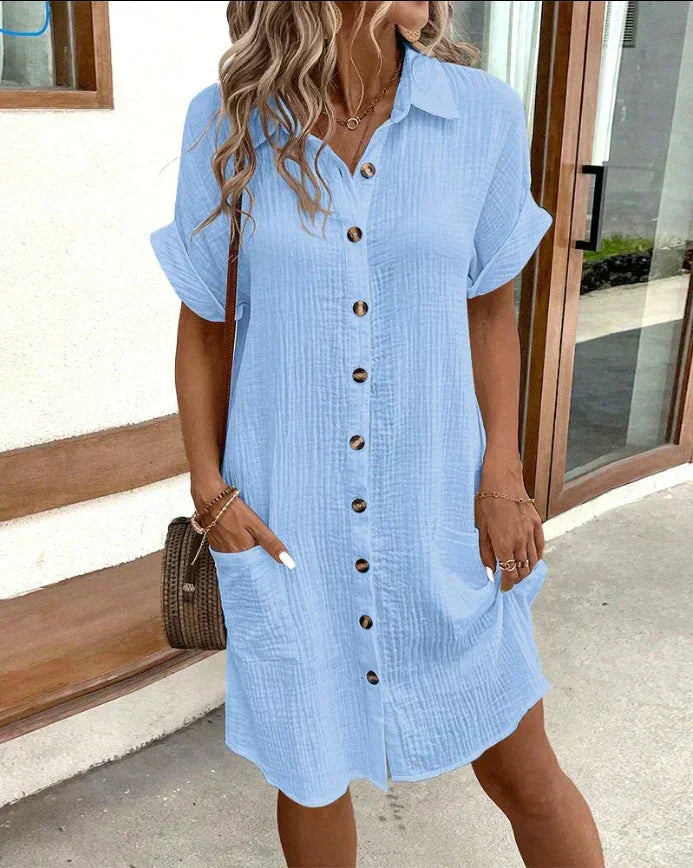 "Women's white cotton polo shirt dress with pockets, featuring a relaxed fit, polo collar, and wrinkle-resistant fabric."