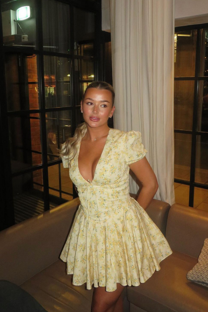 Trendy women's short yellow floral dress, puff sleeves, open back, A-line silhouette. Perfect for summer events.